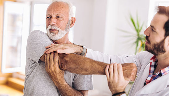 Elderly man receiving shoulder adjustment from Louisville chiropractor