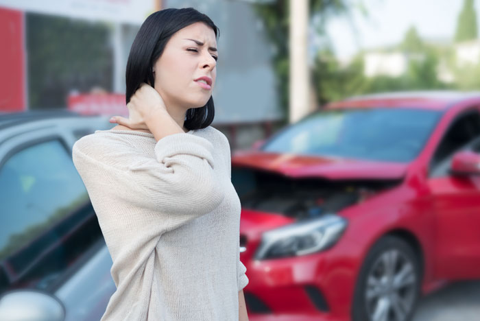 Man with whiplash from auto accident holding his neck in pain before visiting Louisville chiropractor