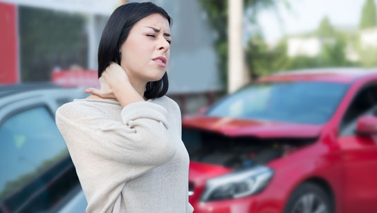 Man with whiplash from auto accident holding his neck in pain before visiting Louisville chiropractor