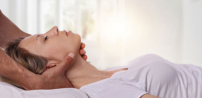 Woman receiving neck adjustment from Louisville chiropractor