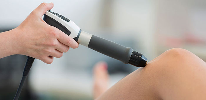 Patient receiving shockwave therapy in Louisville for auto accident injury
